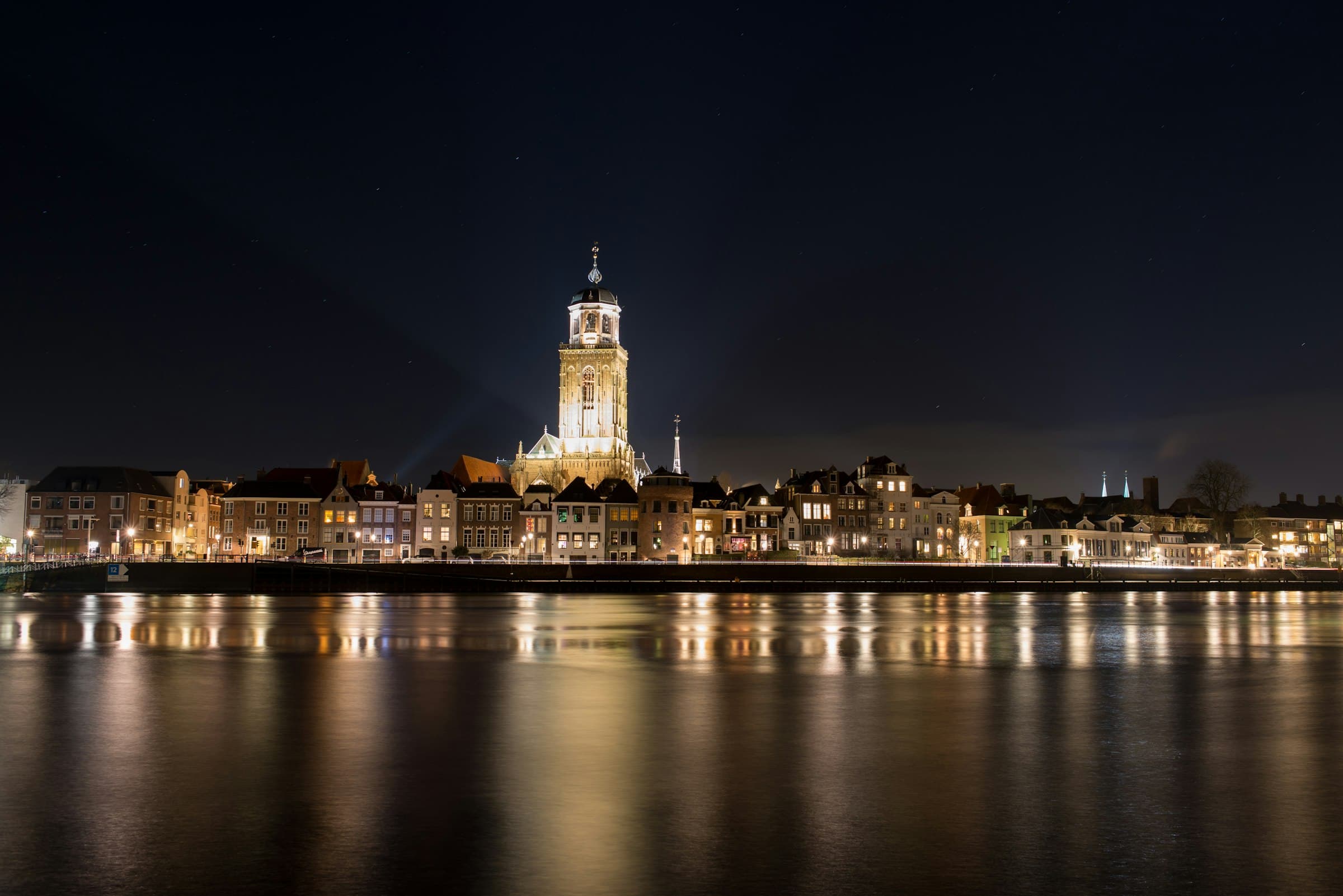 Deventer bij avond, met de verlichte Lebuinustoren aan het water